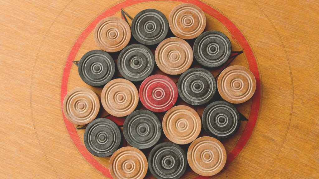 A top-down view of the center for a Carrom board with the pieces organized there