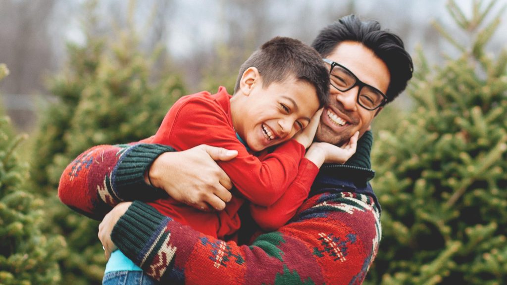 Photo of a son hugging his father outdoors