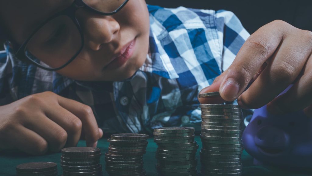 Little boy counting his coins