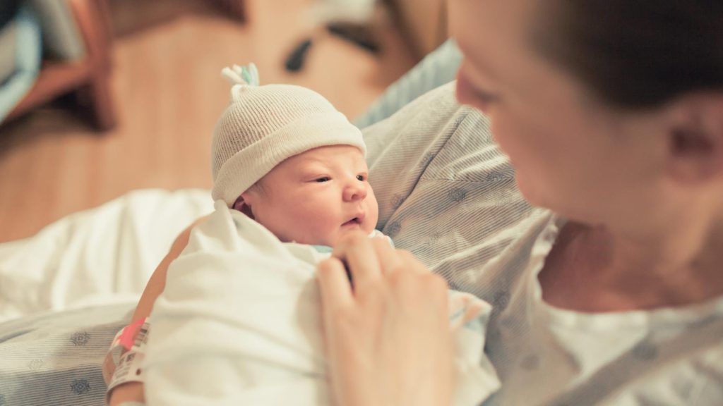 Photo of a new mom holding her newborn child